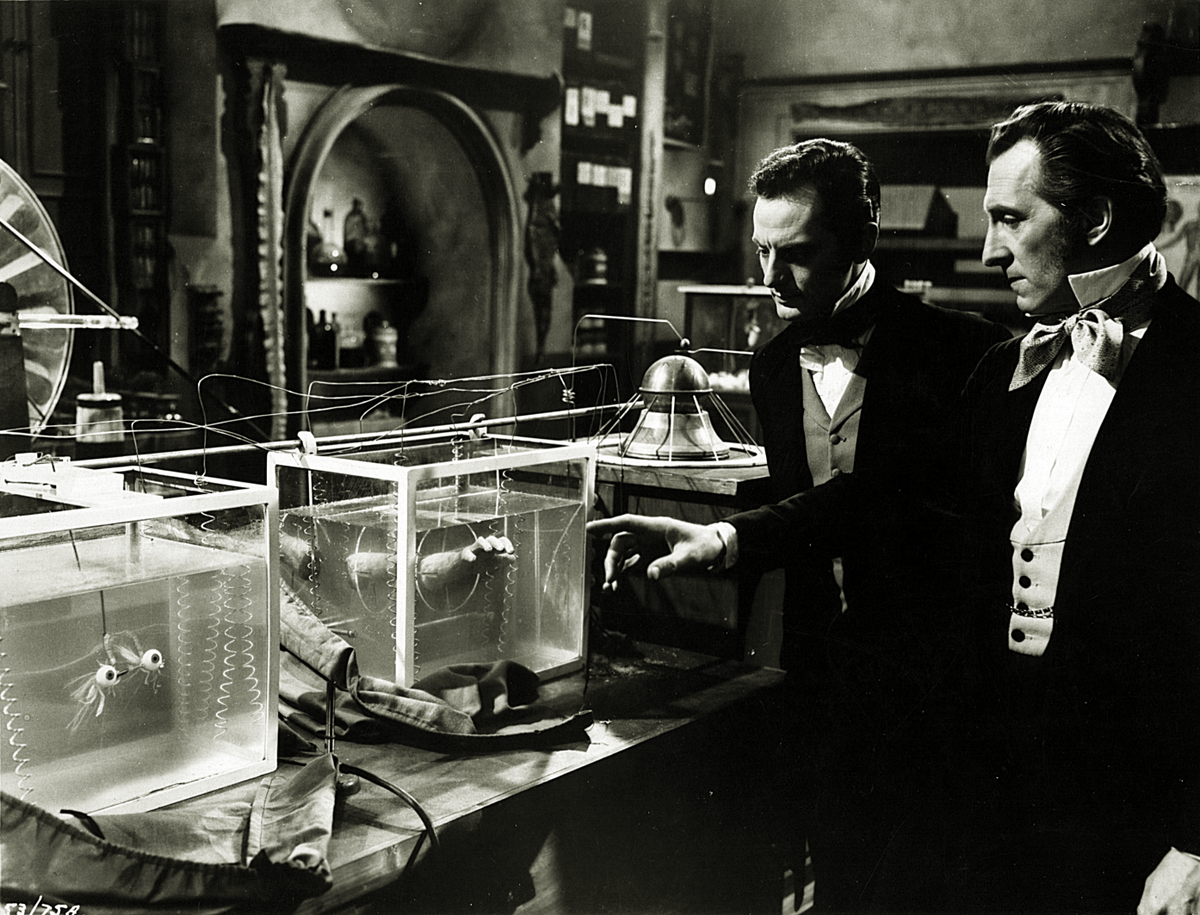 A monochrome film still of Peter Cushing and Francis Matthews from the 1958ย British horror film, The Revenge of Frankenstein.